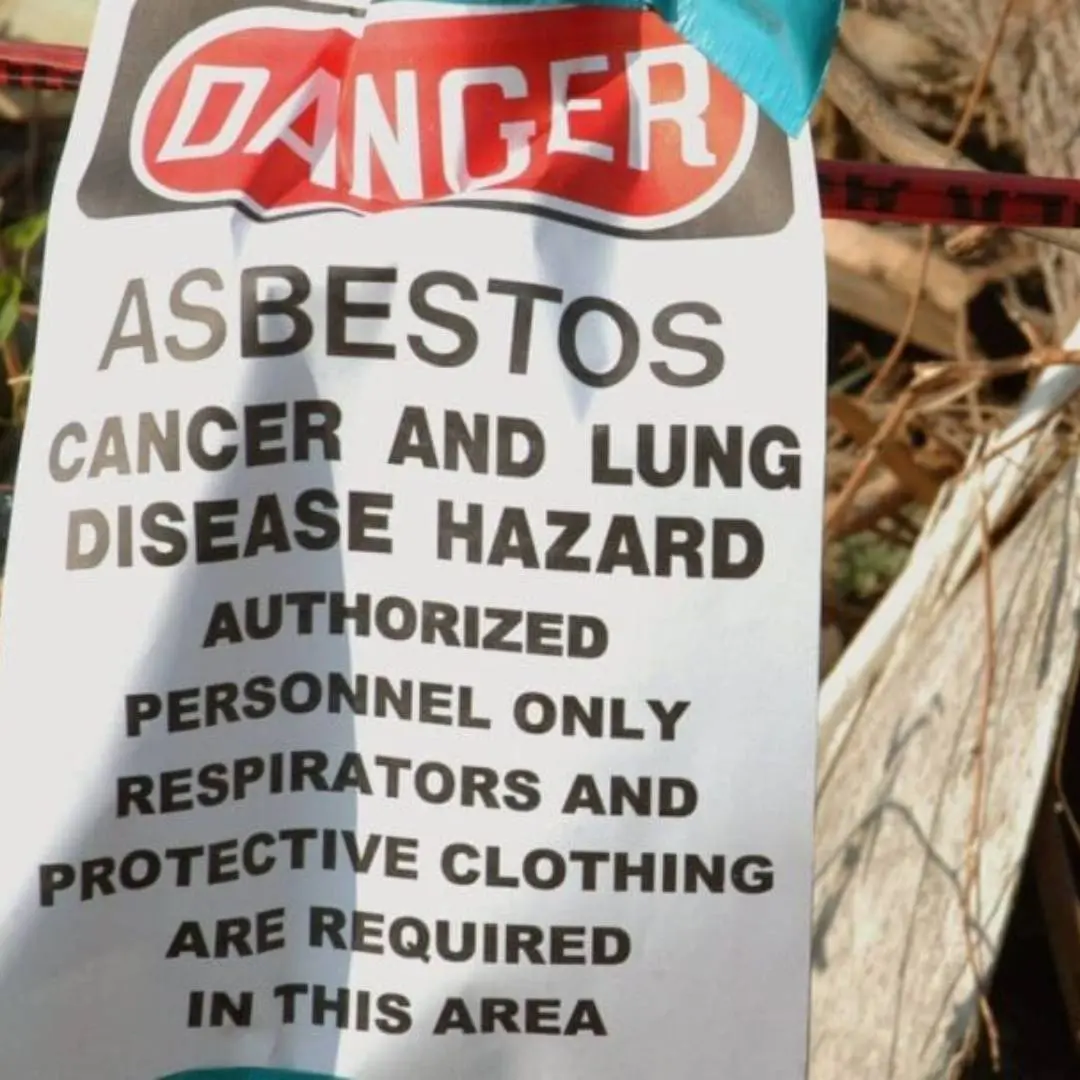Danger sign indicating asbestos hazard, emphasizing cancer and lung disease risk, with instructions for authorized personnel to wear respirators and protective clothing.