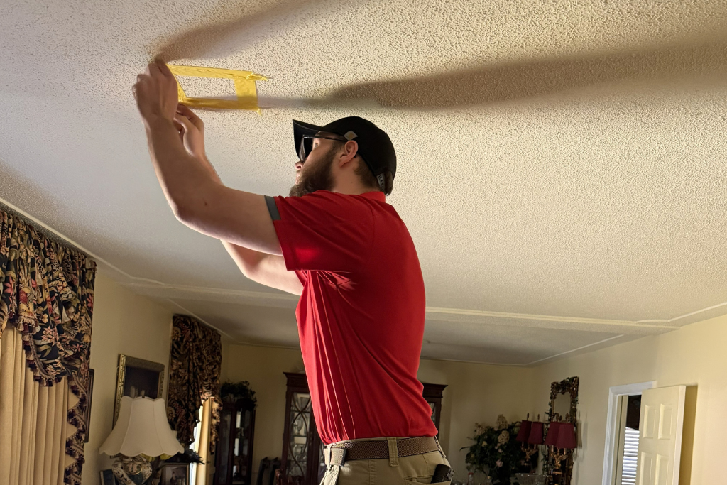 Asbestos Inspector from EnviroPro 360 checks a popcorn ceiling for asbestos.